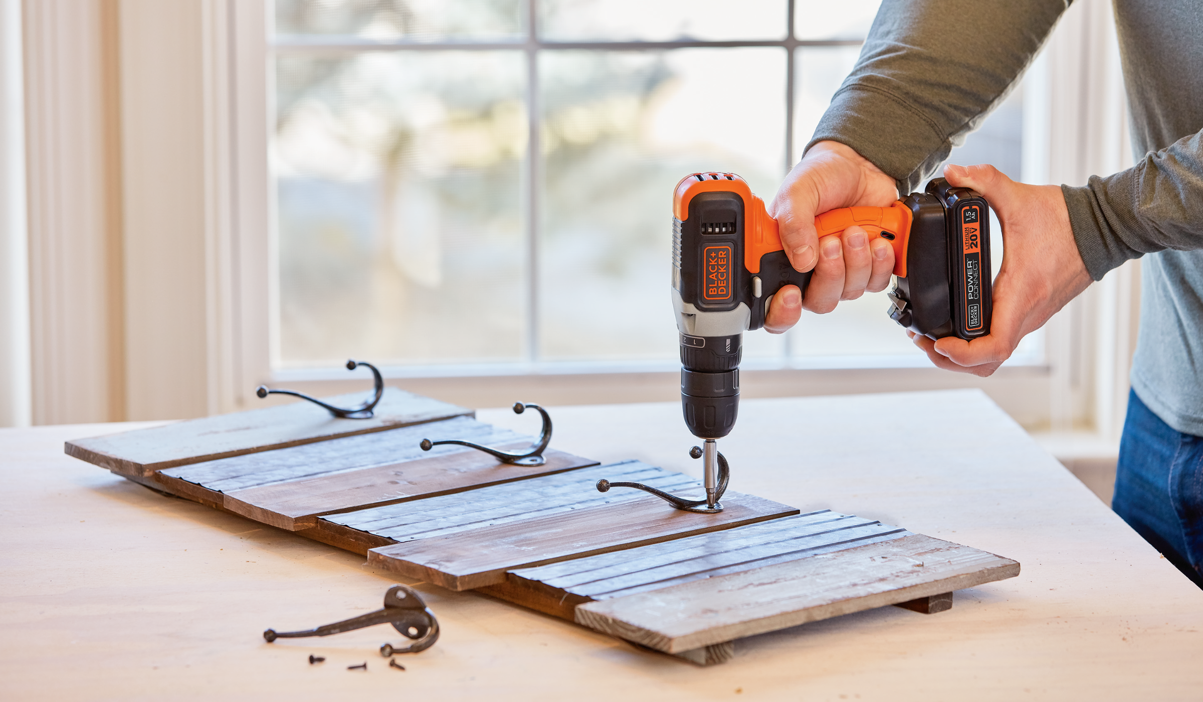 Person using BLACK+DECKER cordless drill