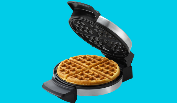 open waffle maker with finished waffles on blue background