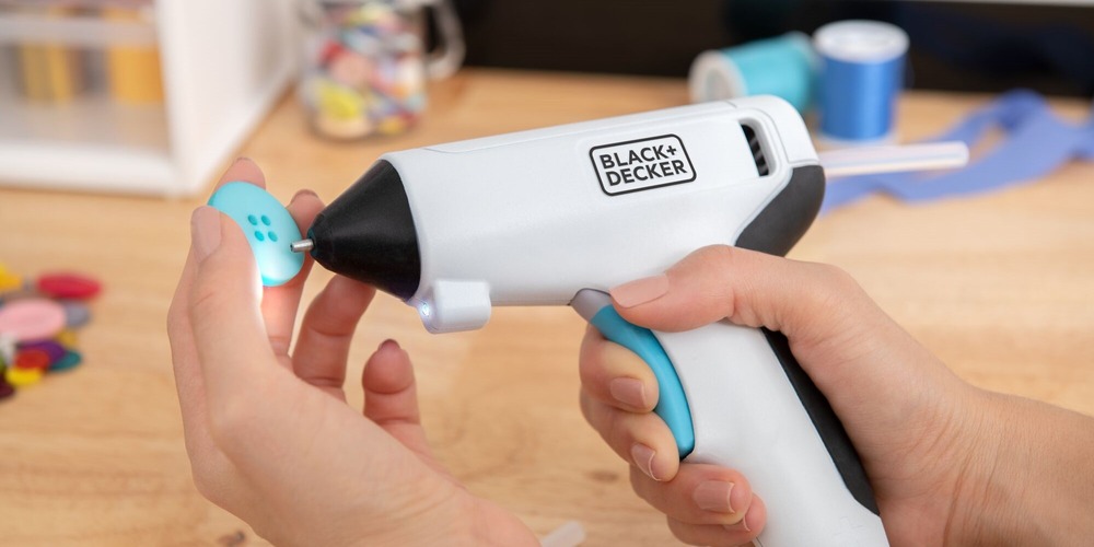 close-up of a BLACK+DECKER cordless glue gun being used to add glue to a decorative button