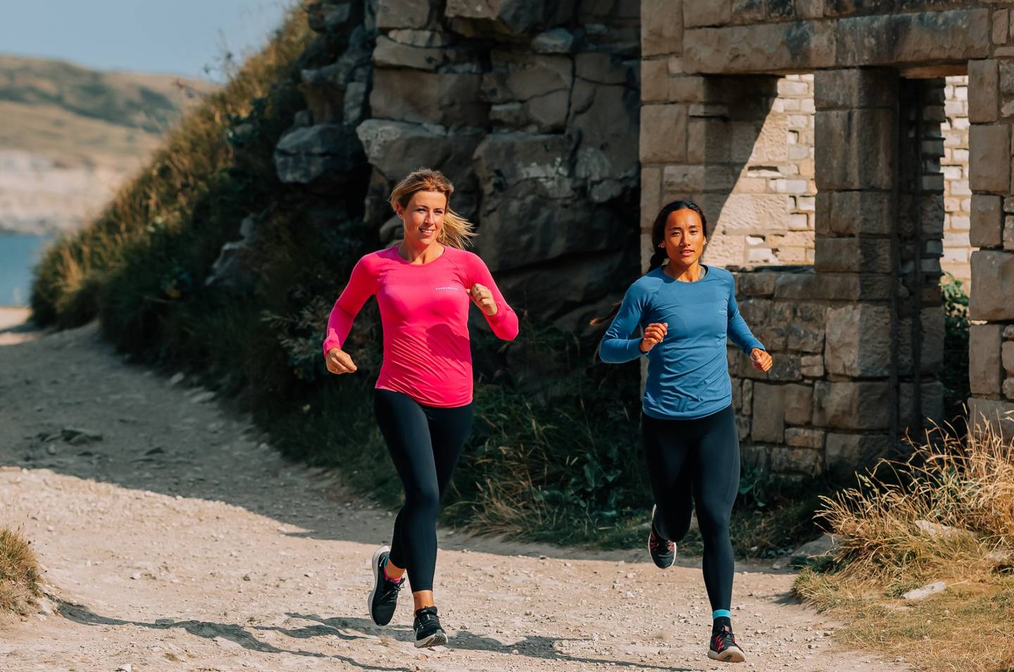 Two Women Running In Coastal Setting In Runderwear Base Layers Pink Blue