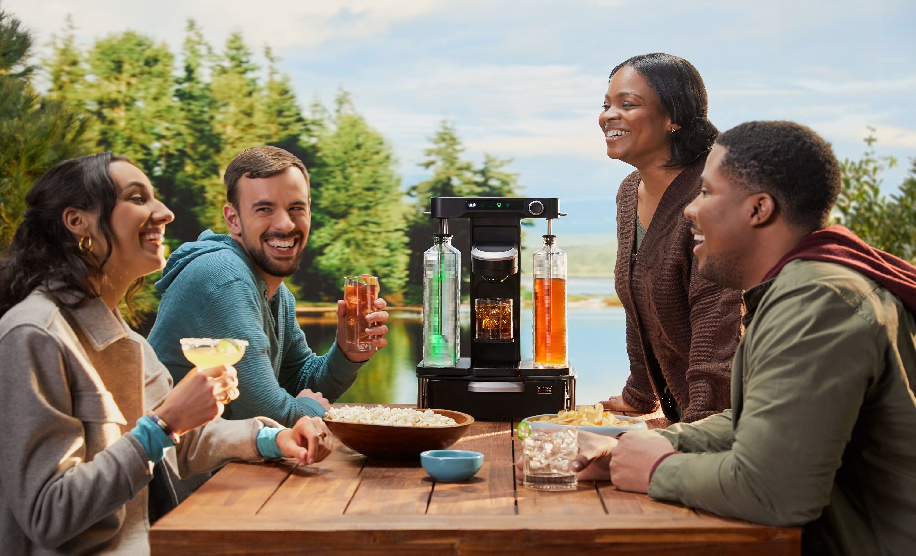 Friends enjoying BLACK+DECKER cocktail maker by a lake