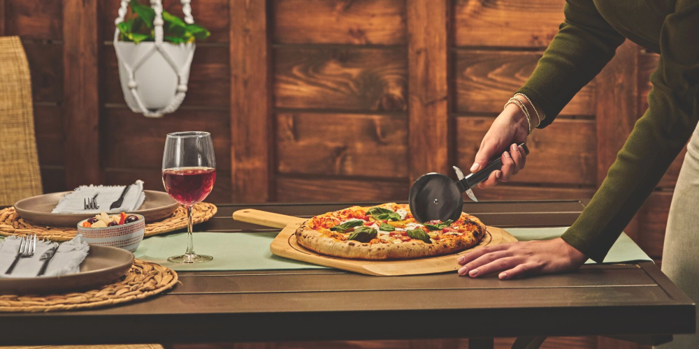 Woman cutting pizza on a table