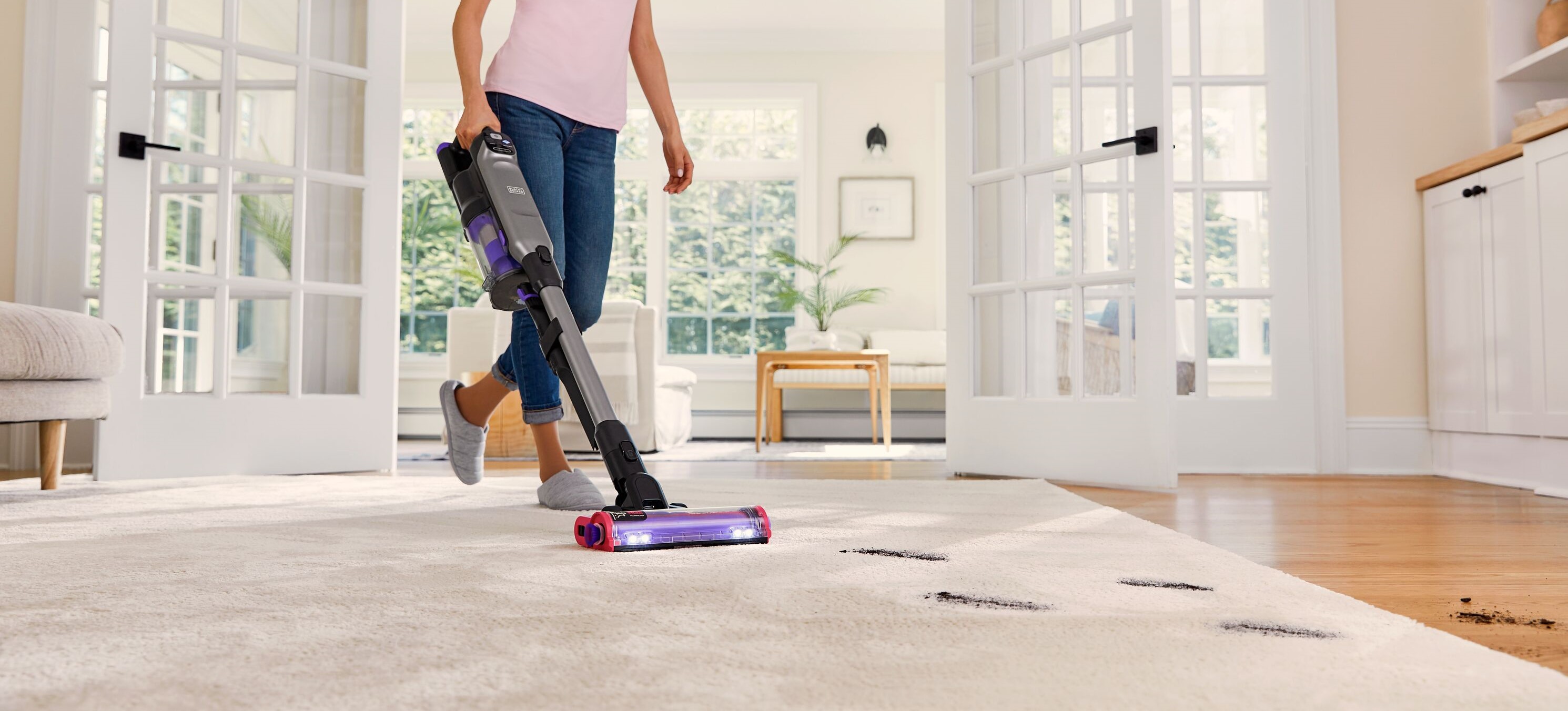 BLACK+DECKER SUMMITSERIES cordless stick vacuum vacuuming dirt off rug