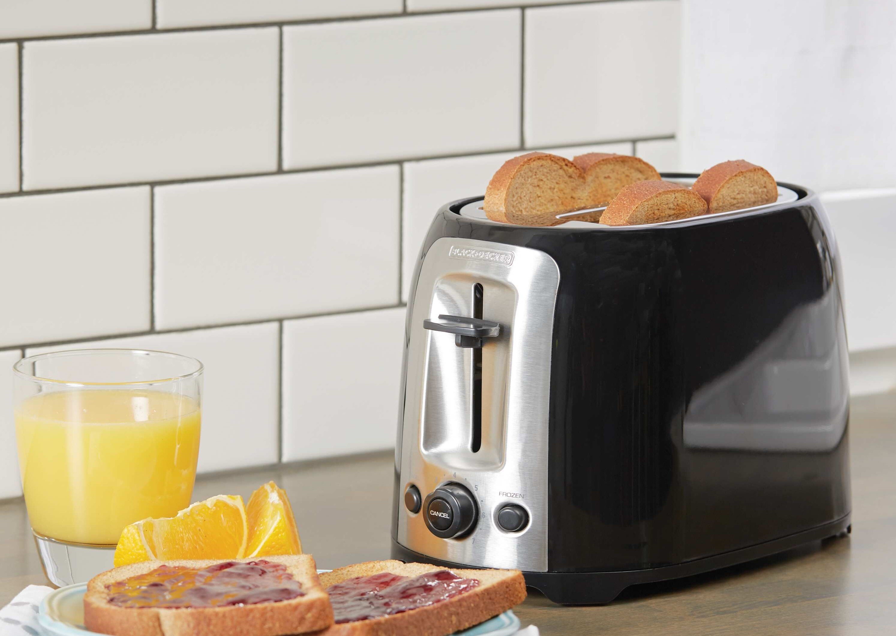 2 Slice Toaster protruding toasted bread placed on kitchen countertop along with breakfast.