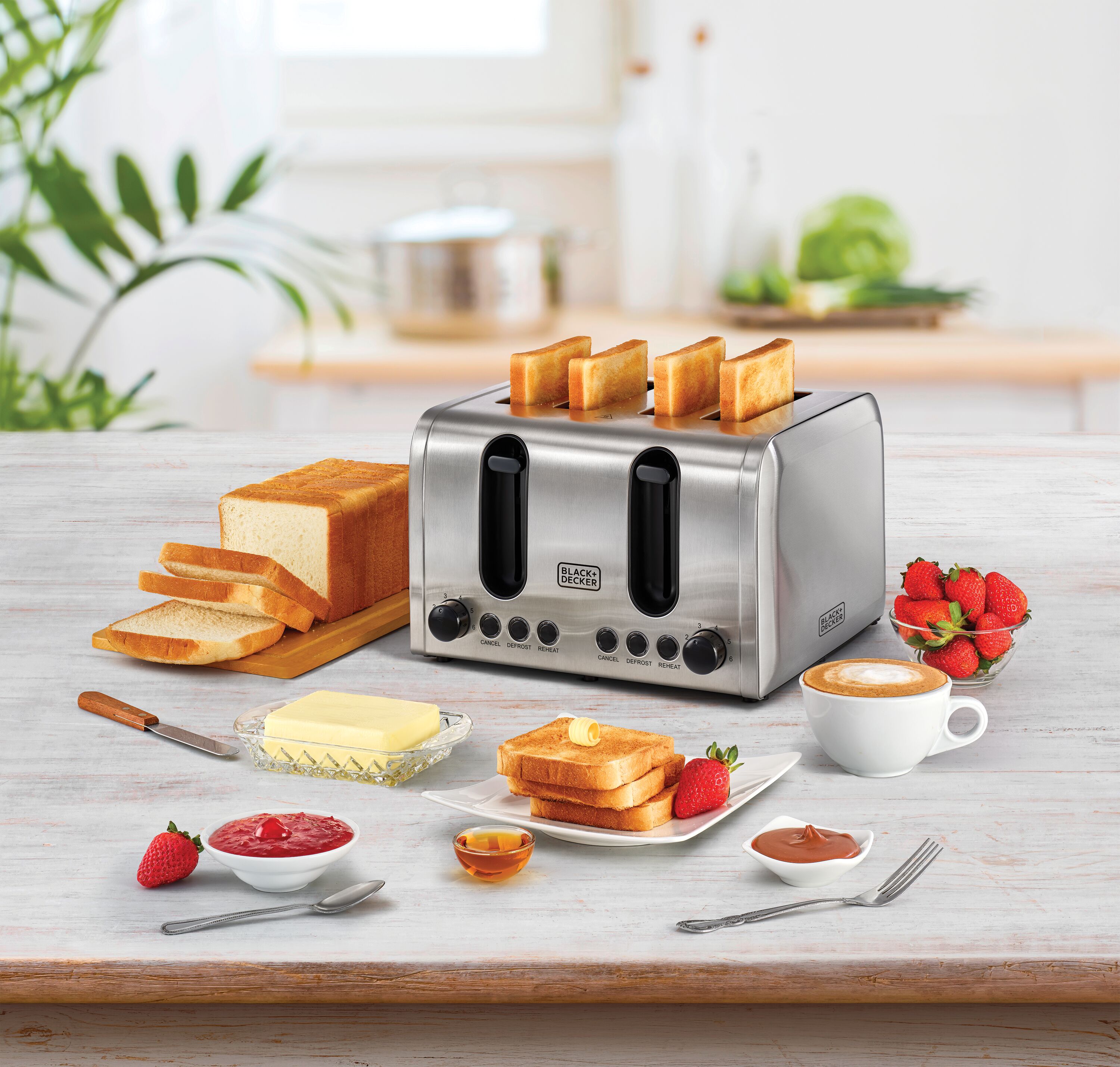 4 Slice Toaster Black and Decker unit placed on the kitchen table with breads butter strawberries and honey