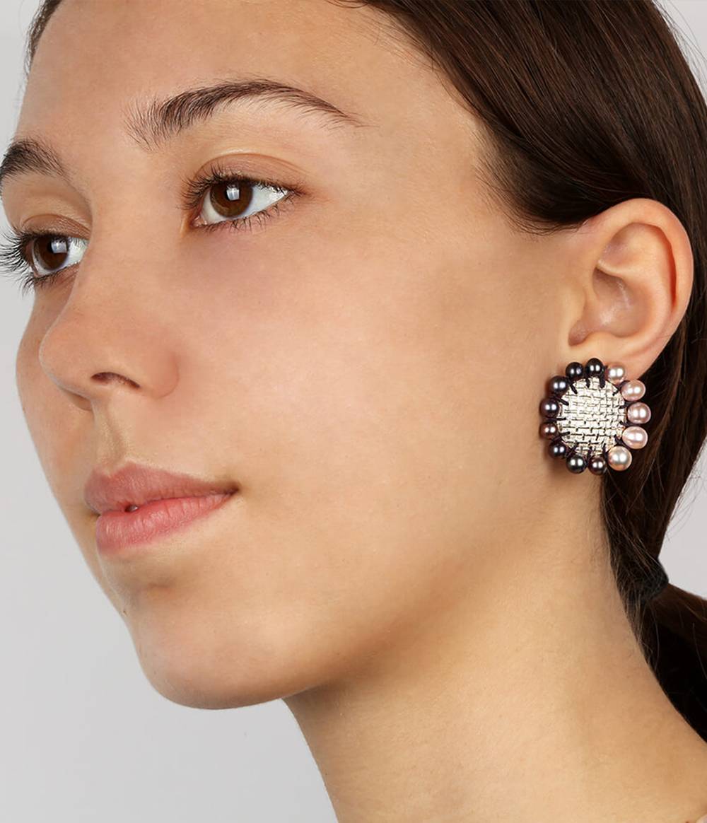 Girl wearing silver round earrings with pink and peacock pearls all around from the Coco jewellery collection.