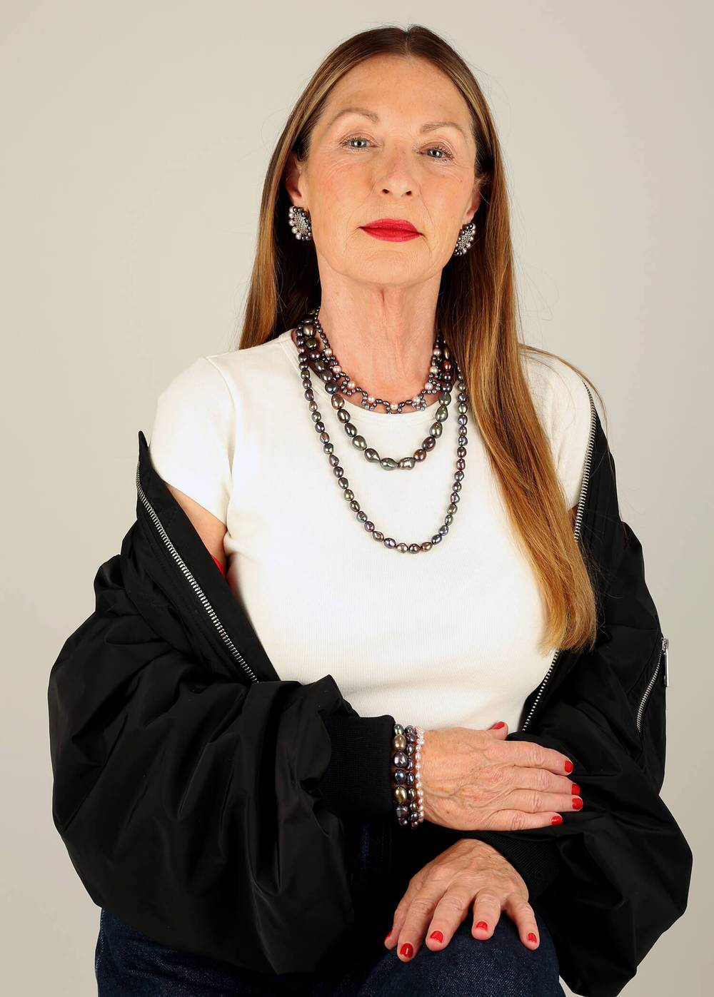 Woman is wearing a set of pearl jewellery in peacock and pink pearls.