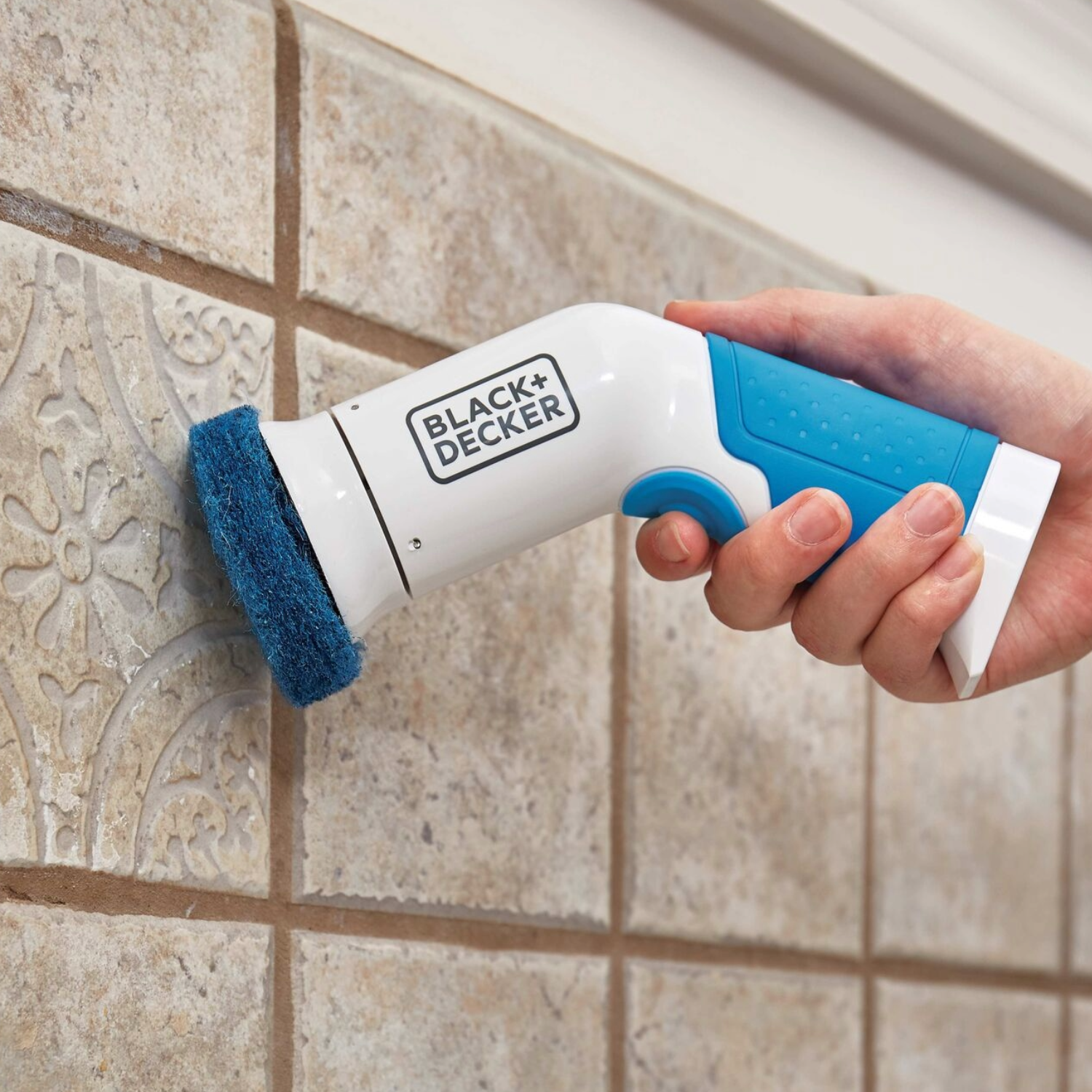 Cordless handheld scrubber being used on tile