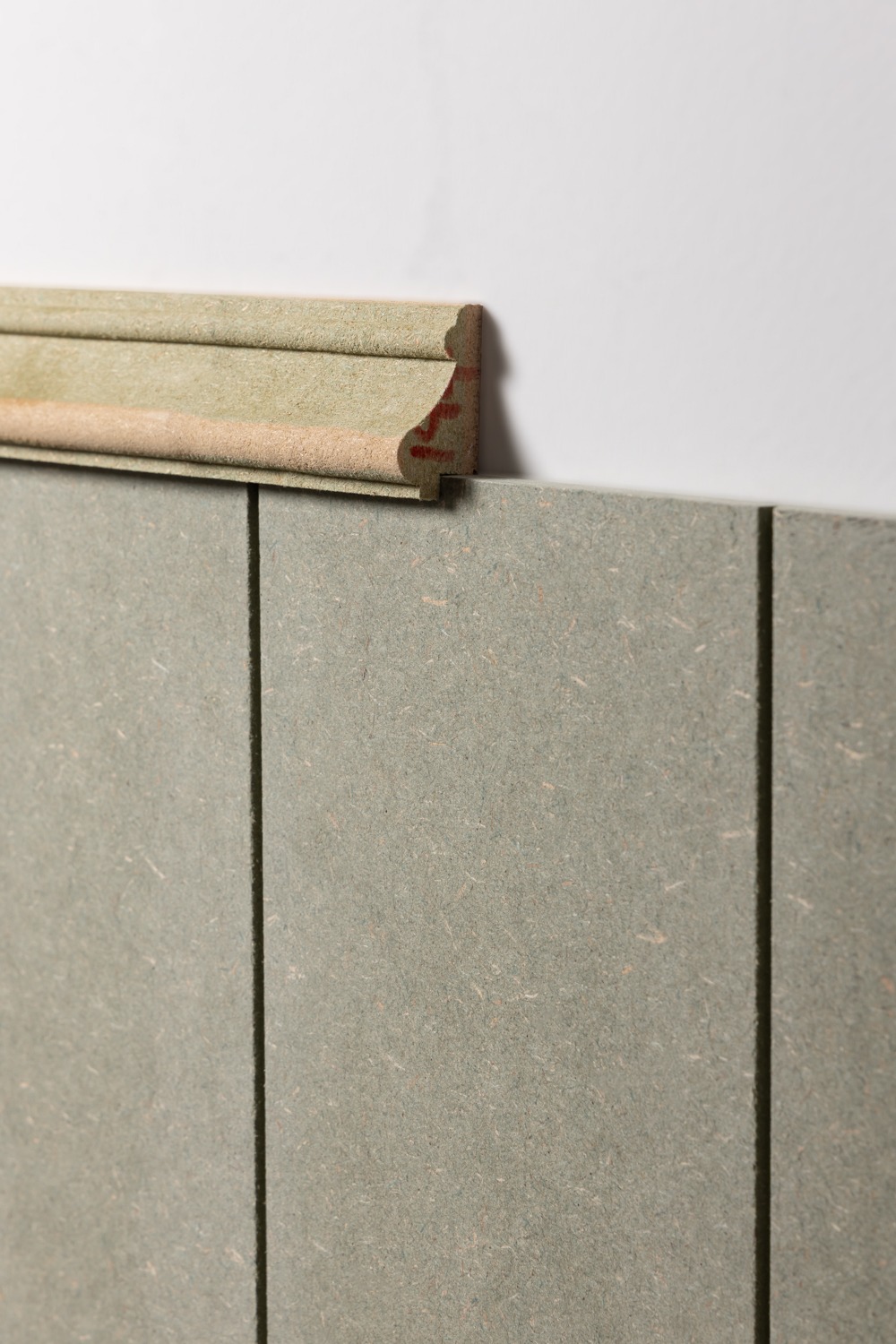 image to show an unprimed dado rail being used as a top trim for wall panels