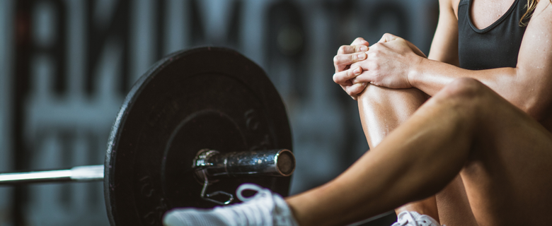 Lady in the gym with a sore knee joint - improve your joint health with U Perform Active Sport Collagen