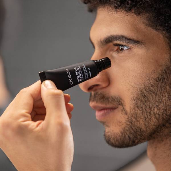 Model applying Cardon's Dark Circle Eye Rescue to his under eye bags