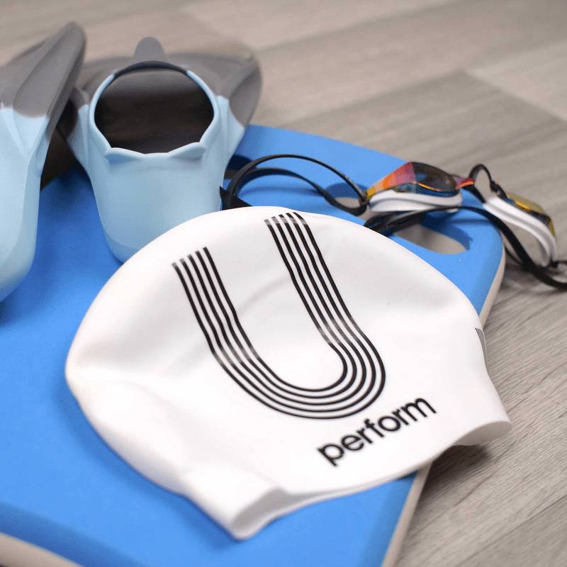 white and black silicone swimming cap with swimming fins and goggles 