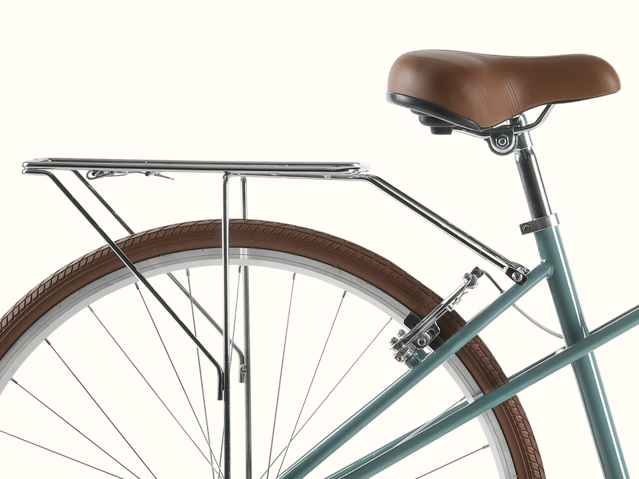 A close-up of the teal Kinney Mixte City Bike - 7 Speed's rear rack and brown saddle.