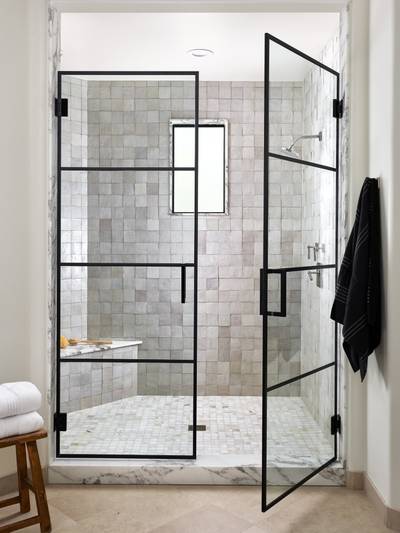 clé tile zellige 4x4 in weathered white covering an all white shower with a black metal door.
