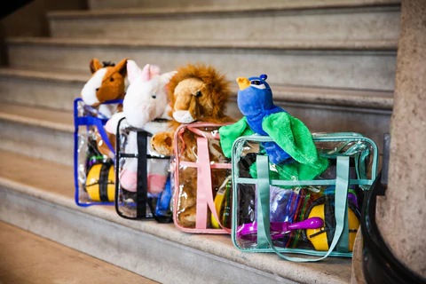 An image of clear plastic sensory bags filled with sensory activities like fidget toys, noise cancelling headphones and hand puppets 