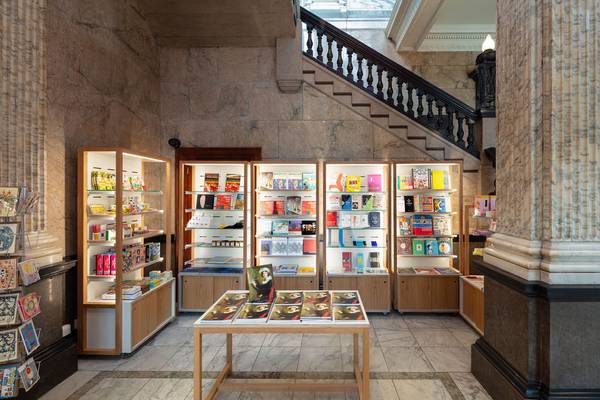 The Shop at the RWA. Shelves display books, catalogues and gifts, the staircase is visible to the top right of the picture.