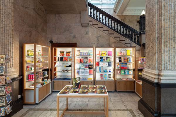 
      The Shop at the RWA. Shelves display books, catalogues and gifts, the staircase is visible to the top right of the picture.