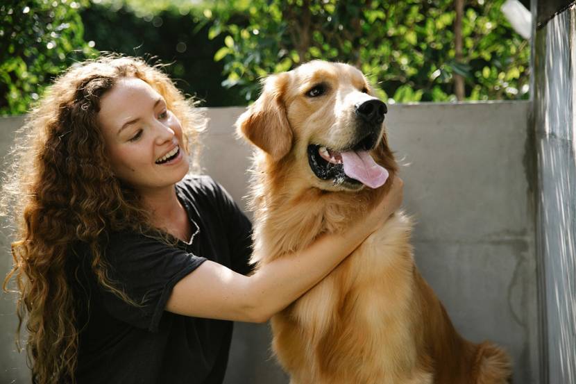 glückliche Frau mit Hund im Arm