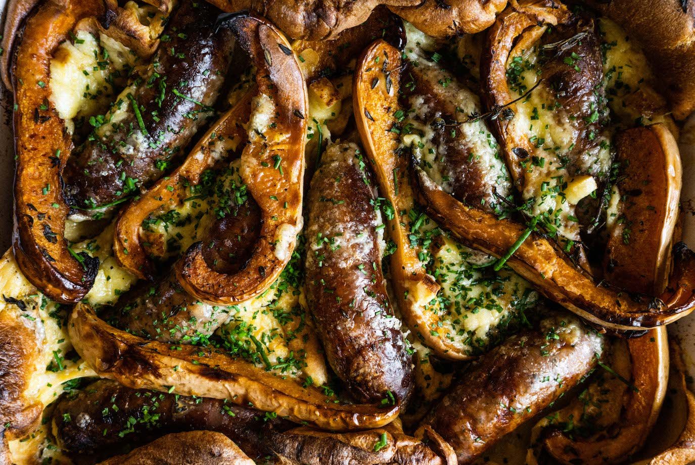 Toad in the hole with baked squash, Cumberland sausages and smoked Quickes cheddar, with onion gravy
