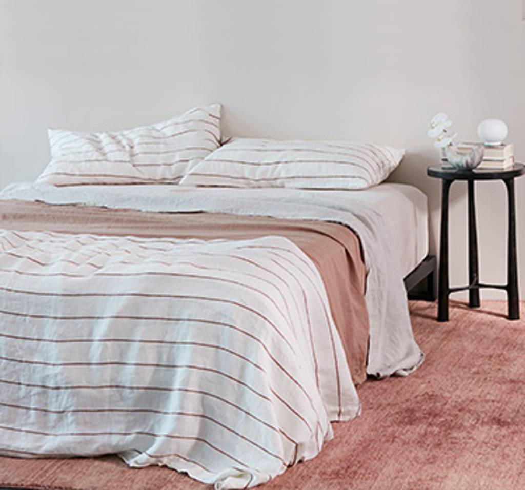 A bed styled with Cedar Stripe, Smoke and Fawn bedding.