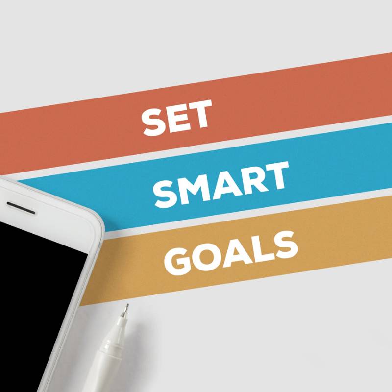 set smart goals infographic with a white mobile phone and white pen as decoration