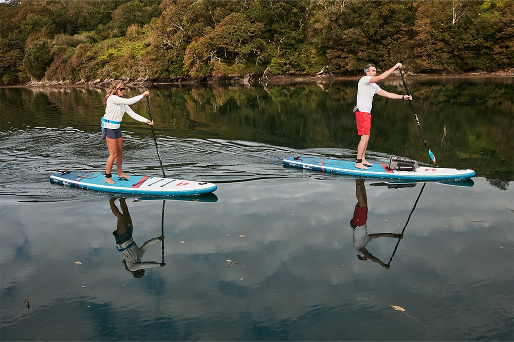Man and woman paddling Red 11’3”paddle board in lake
