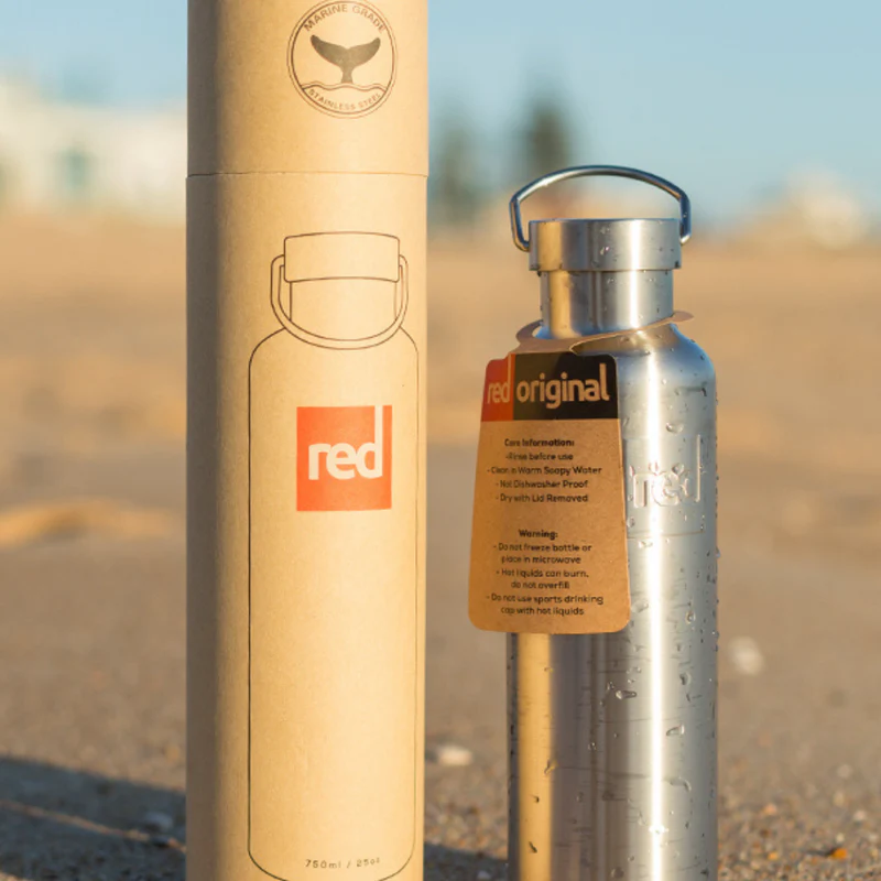 Red Insulated stainless steel water bottle stood next to its packaging
