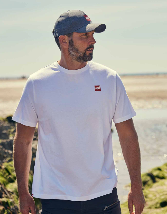 Man walking through the beach wearing a Red Original Lifestyle T-shirt in White
