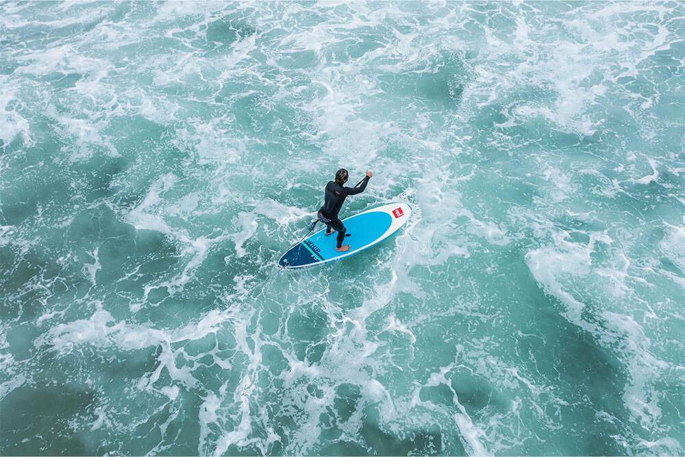 aerial view of man paddling on Whip inflatable paddle board in the sea