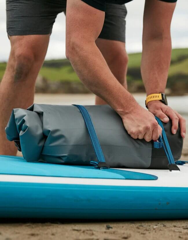 roll top dry bag attached to an inflatable paddle board