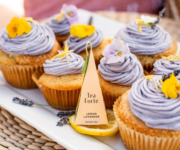 A pyramid tea infuser on a tray of Lemon Lavender Cupcakes with Buttercream Frosting