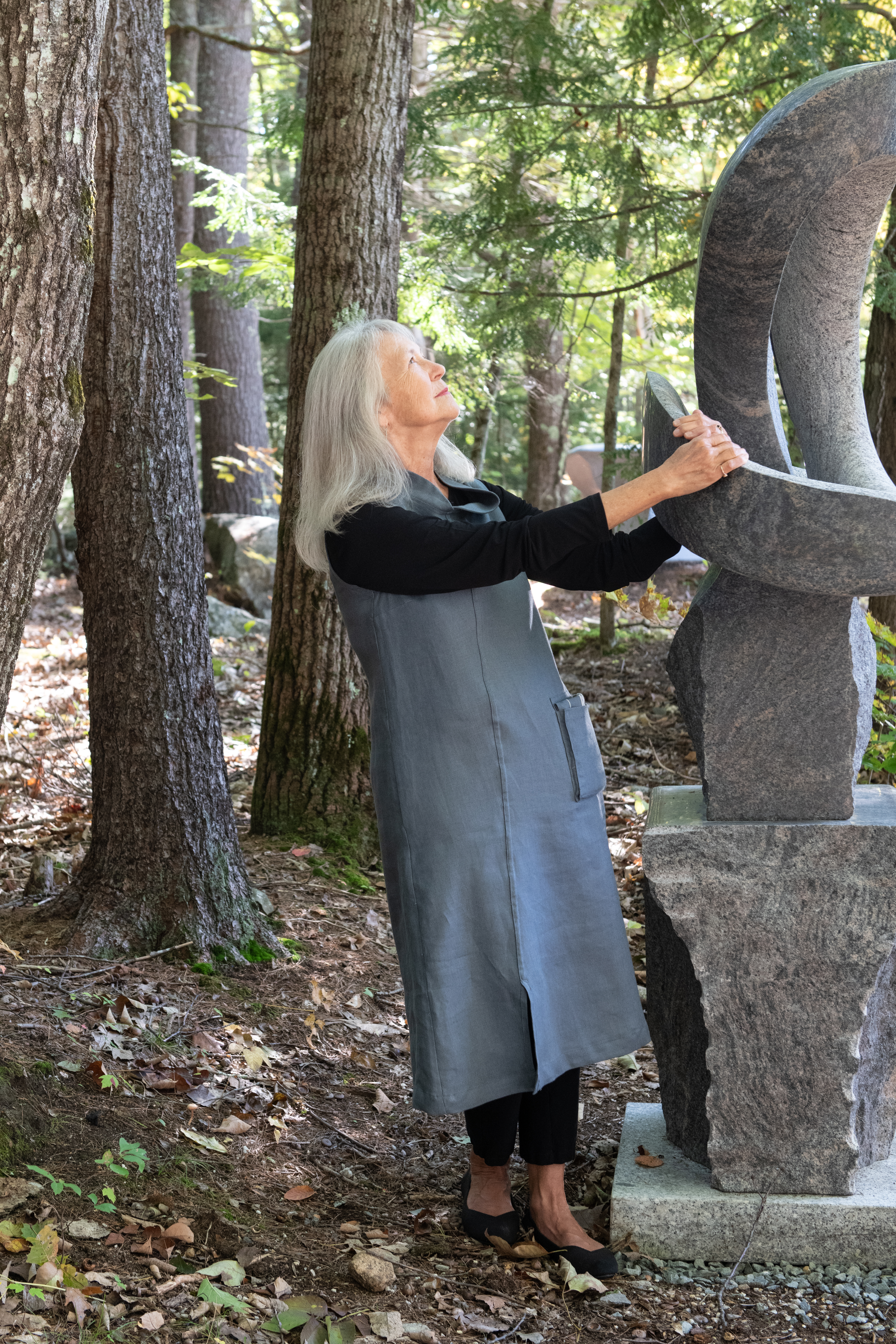June, in the In Libris tunic, holding onto Miles Chapin’s granite sculpture “Bloom”