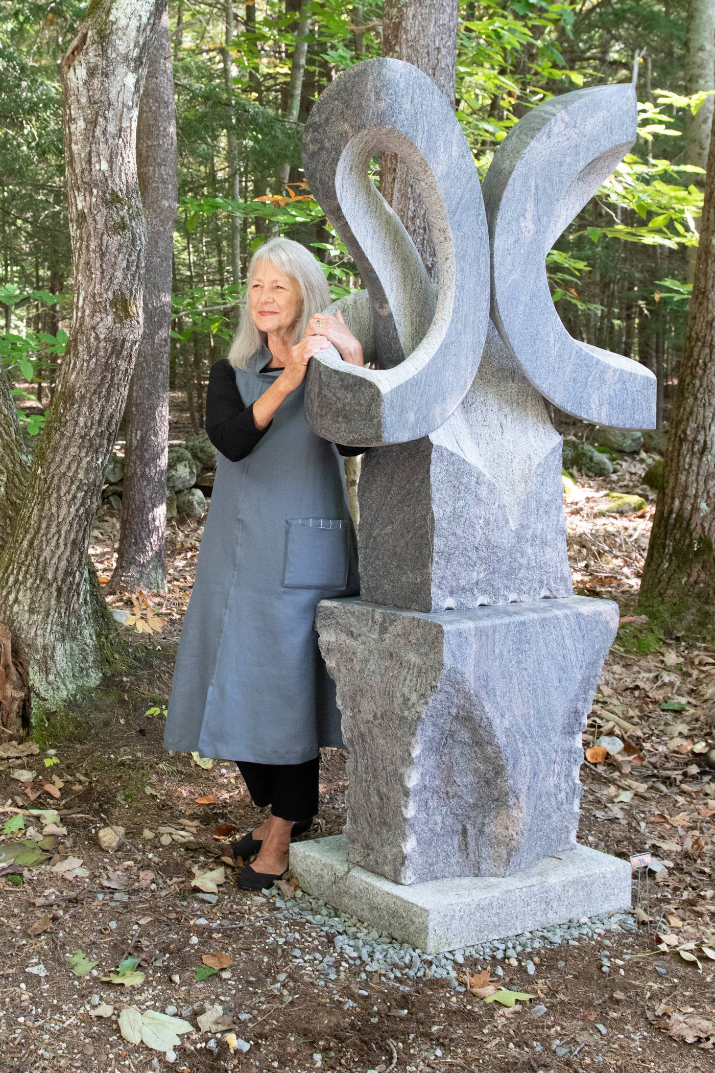 June, in the In Libris tunic, holding onto Miles Chapin’s granite sculpture “Bloom”