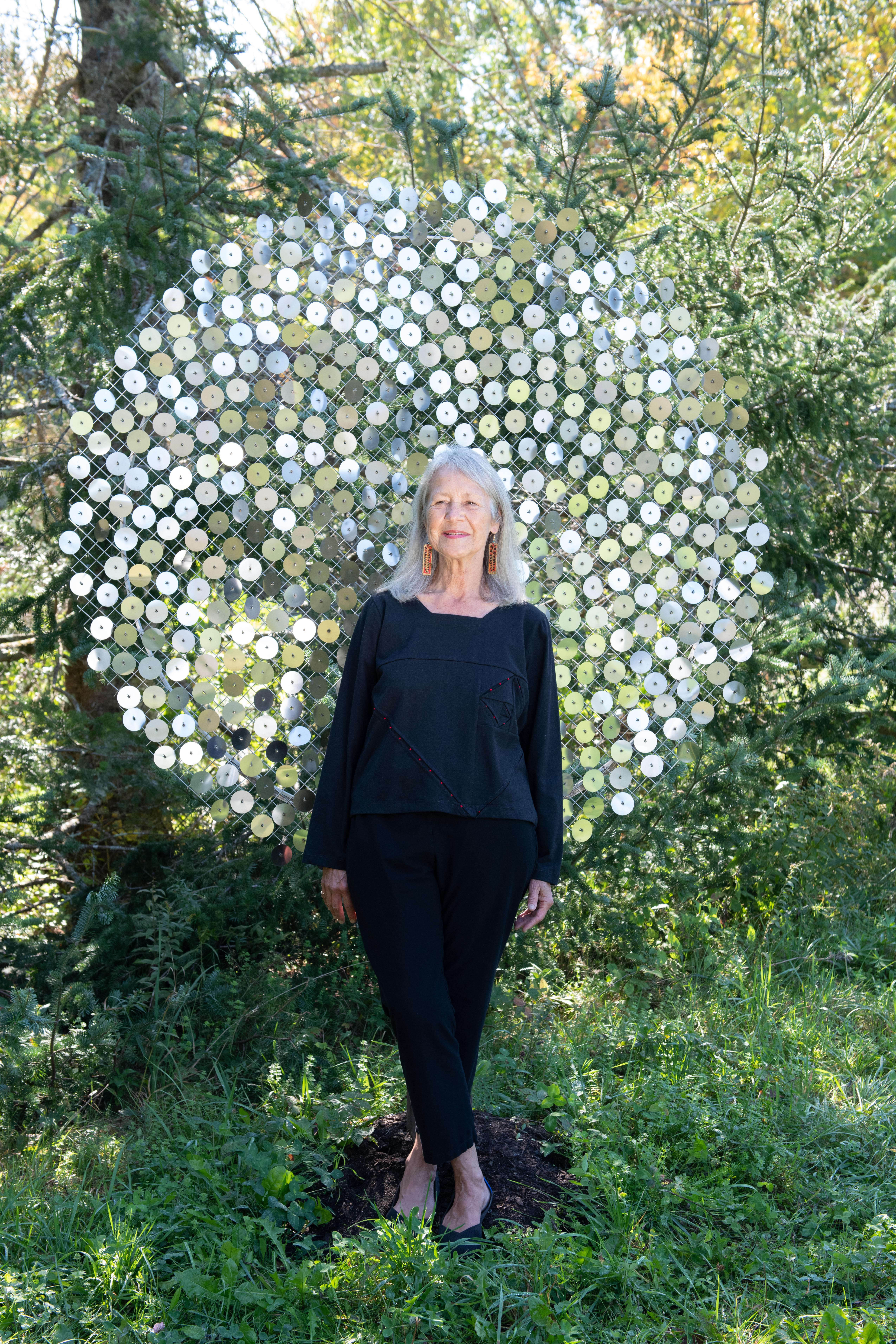 June, in the Body Story top, in front of George Sherwood’s shimmering stainless steel piece, “Memory of Fibonacci”