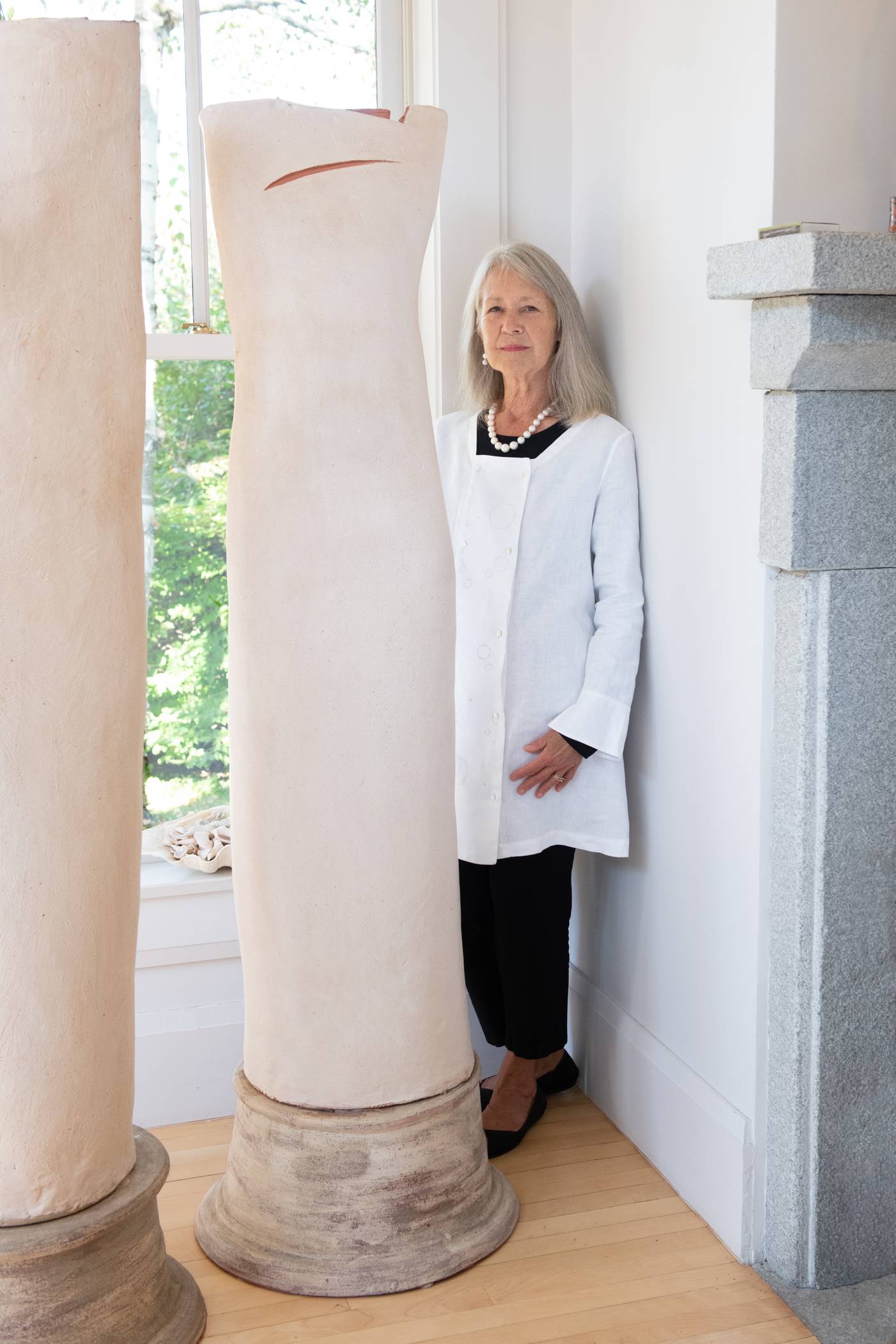 June in the white Medulla tunic, standing next to the ceramic “TreeForms” sculpture by Sharon Townshend