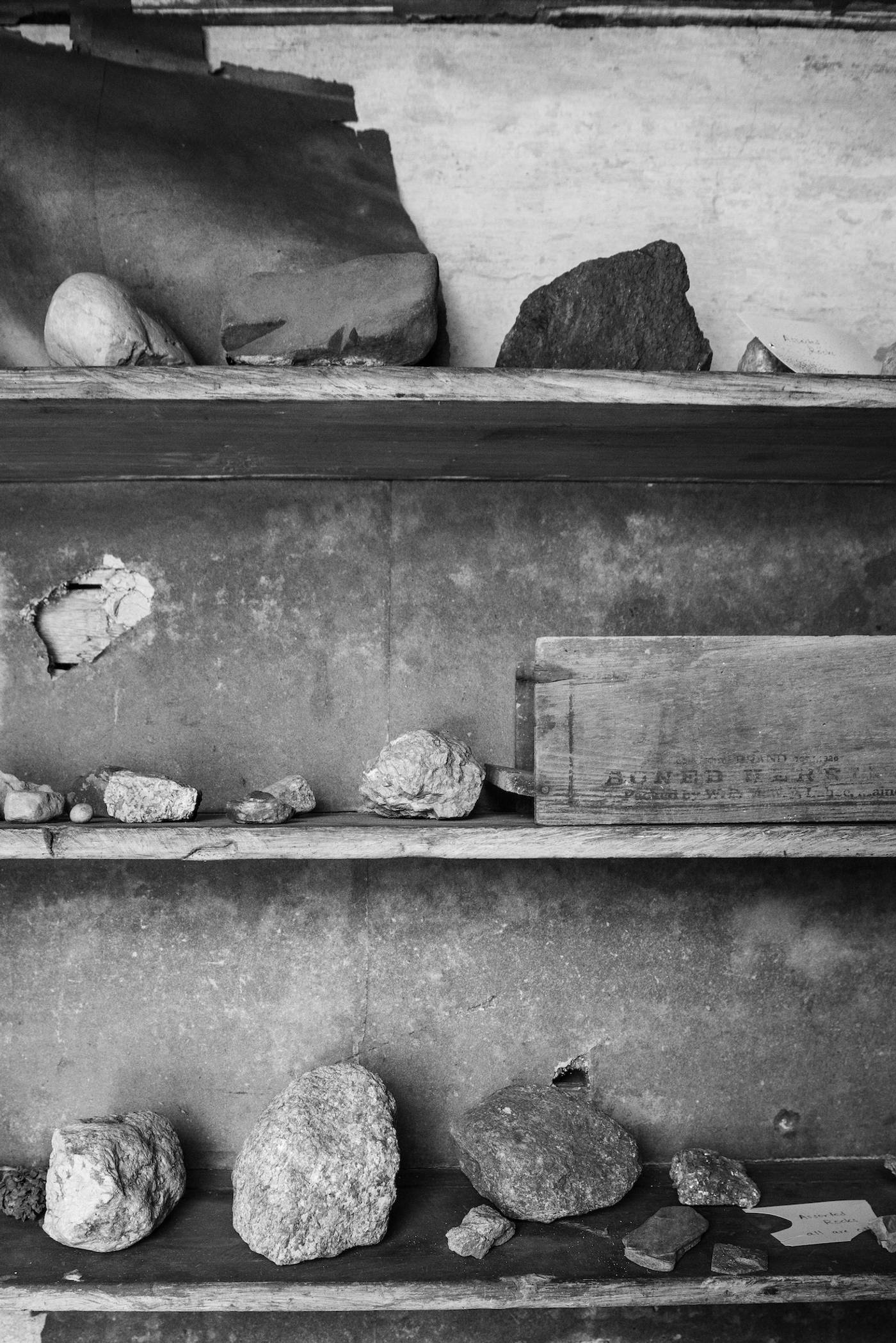 Wooden shelves holding rocks and objects