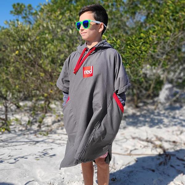 Boy standing on a beach wearing a Grey Microfibre changing robe