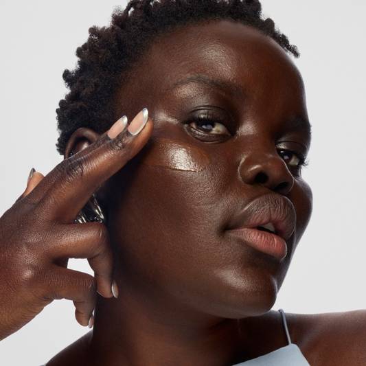 A model applies skin tint foundation