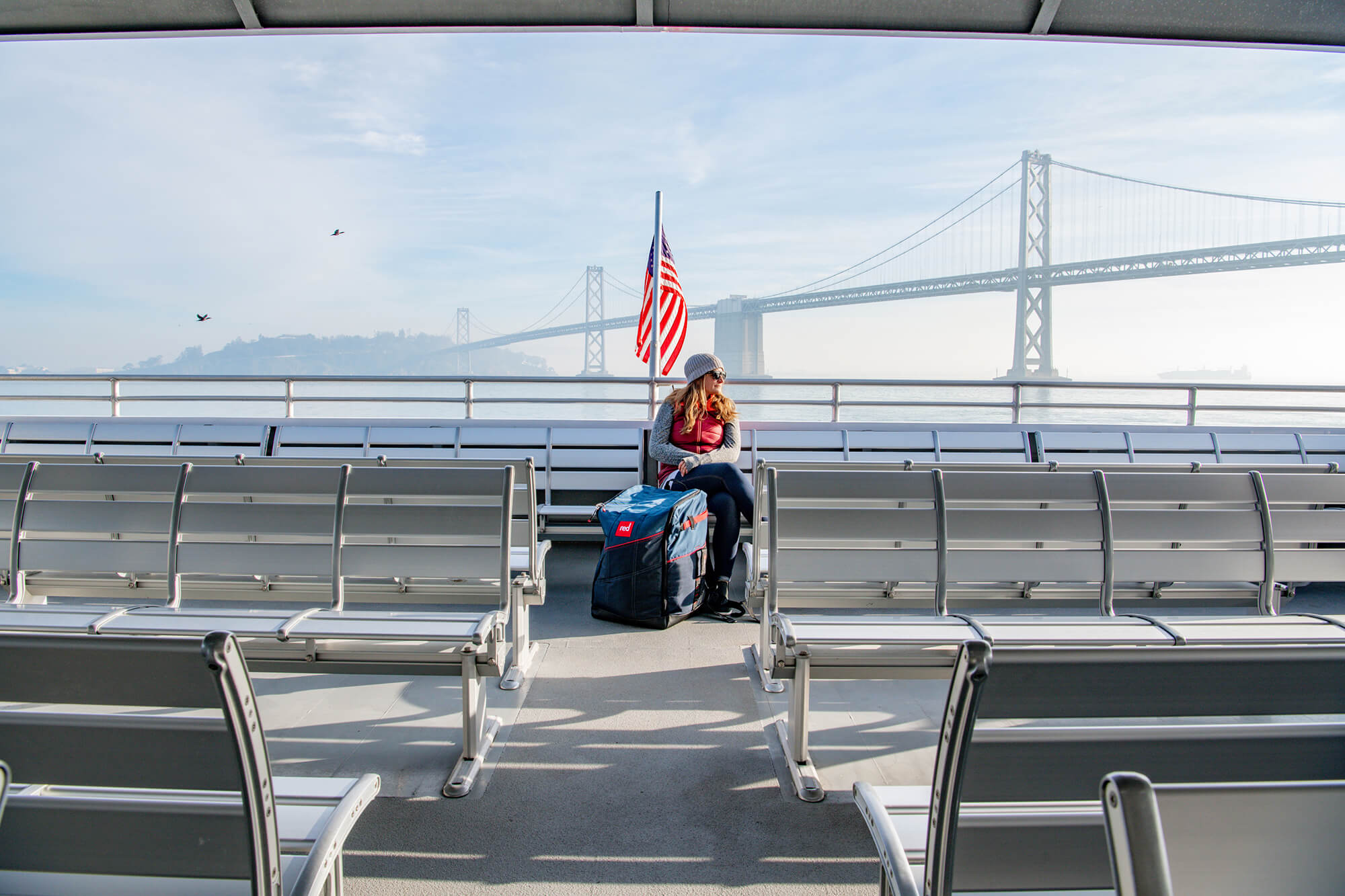 Woman On A Ferry With The San Francisco-Oakland Bay Bridge In The Background