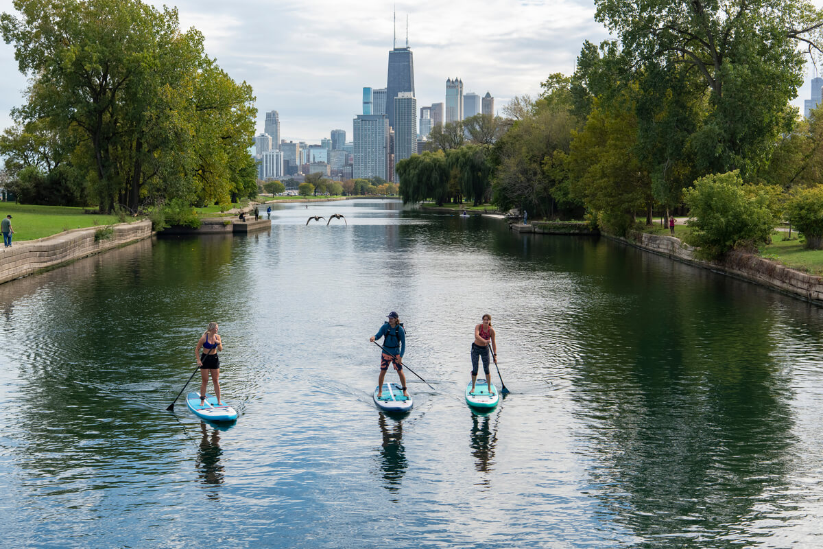 3 women urban paddle boarding in Chicago