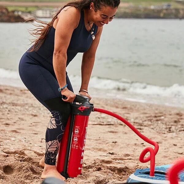 woman inflating an iSUP on a Beach with a Titan Pump