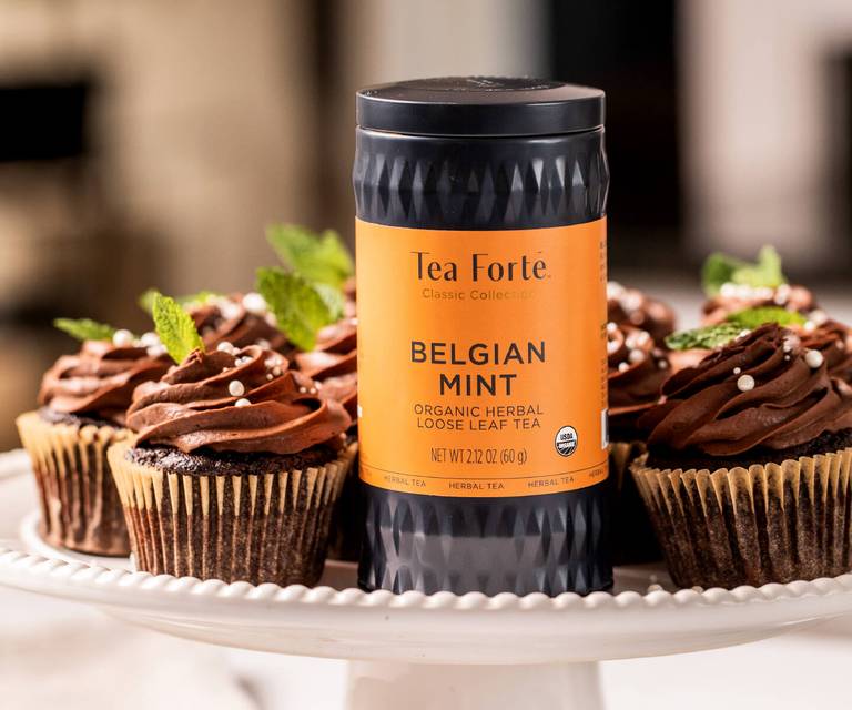 Belgian Mint Loose Tea Canister in front of a tray of Belgian Mint Cupcakes with Whipped Ganache Frosting