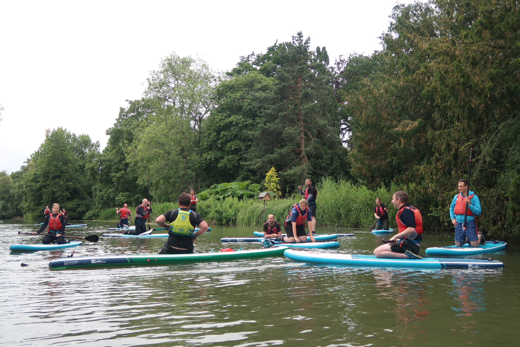 A Class of paddle boarders learning to SUP on the River Leam 