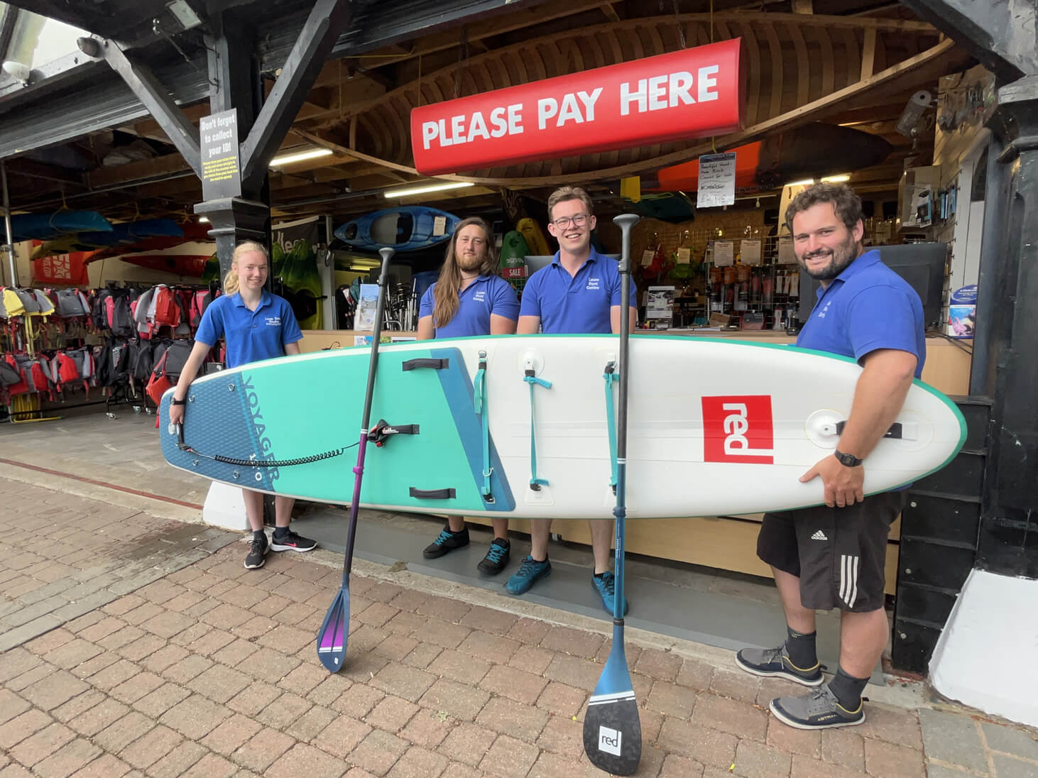 Leam Boat Centre Team holding a Red Paddle Board
