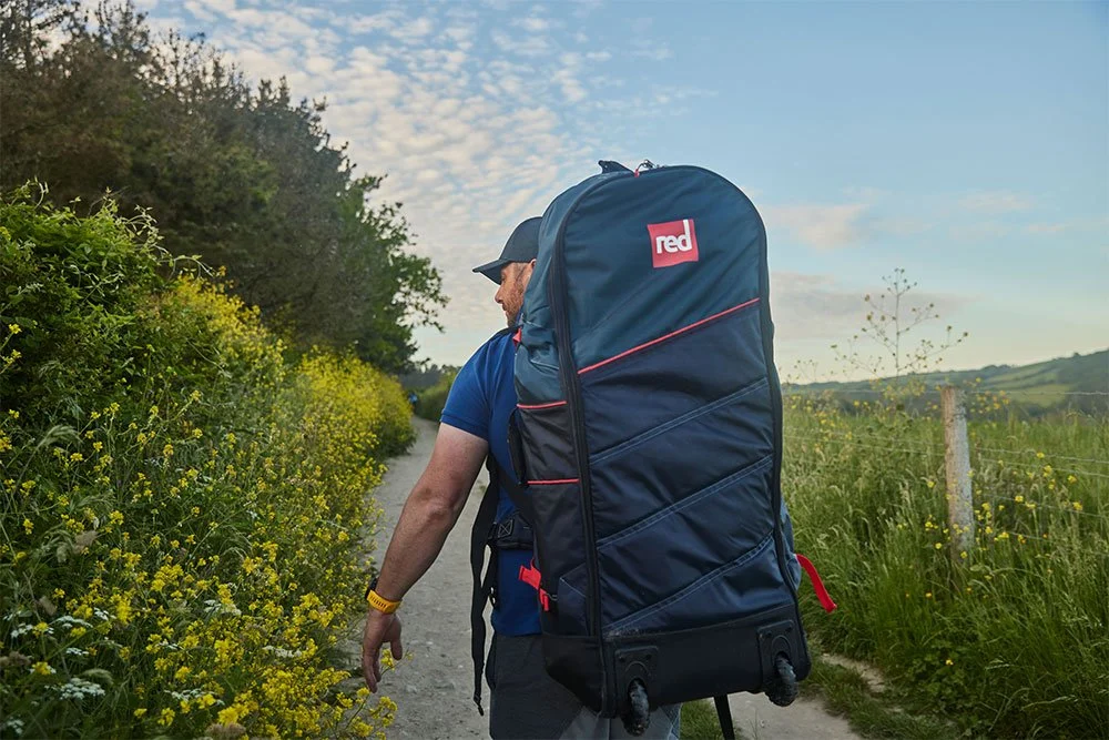Un hombre lleva su bolsa ATB por un camino rural
