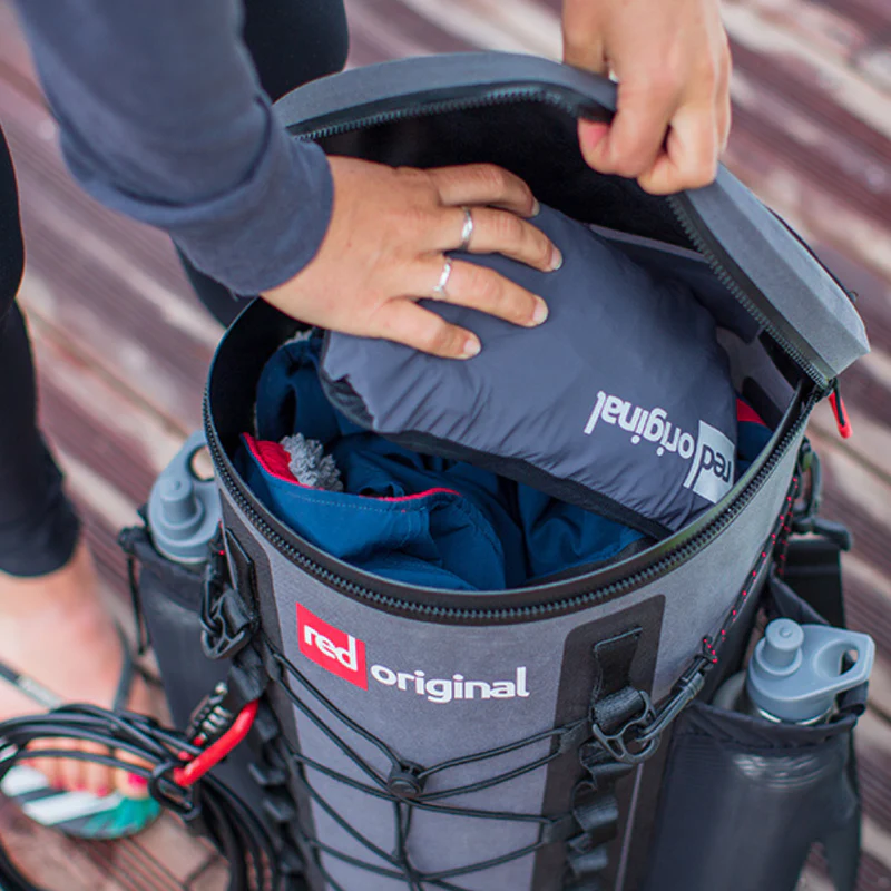 Person packing items into waterproof SUP deck bag
