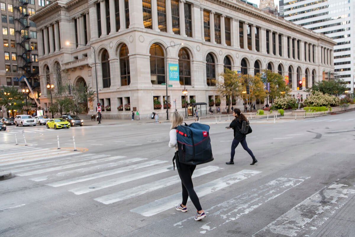 Woman walking through Chicago streets with a SUP carrier on her back