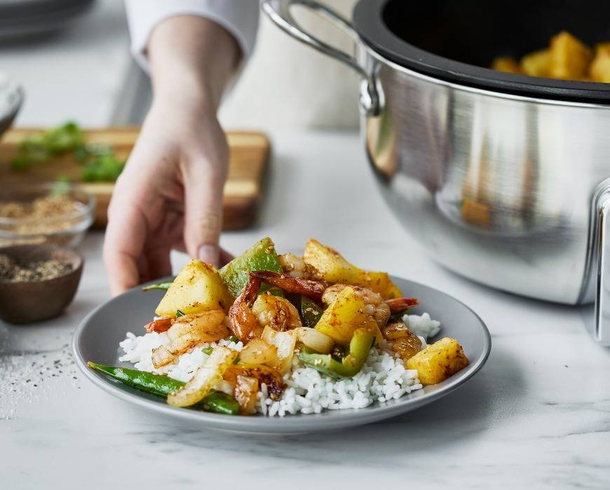 Summer shrimp & veggie stir fry on a plate next to the GreenPan Premiere 6-Quart Essential Smart Skillet.