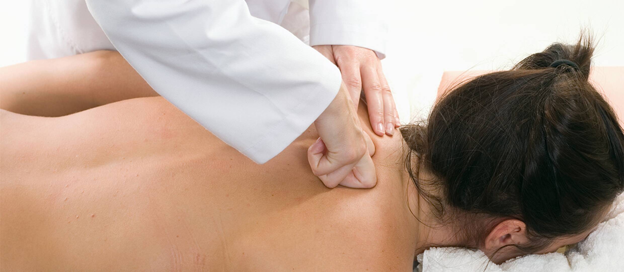 Applying the petrissage technique to a female massage client