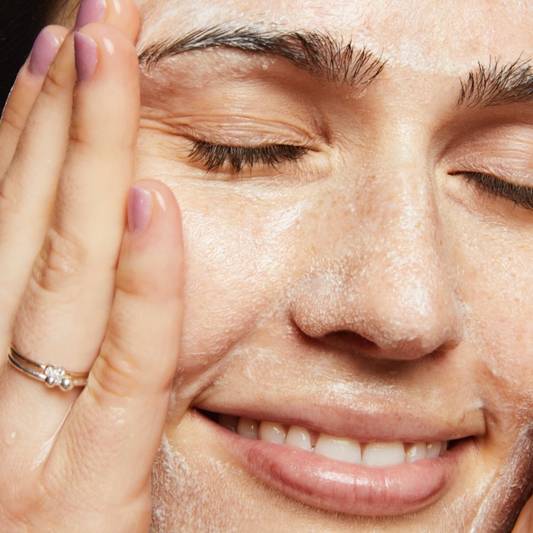  Close-up of model washing her face using Vegan Milk Cleanser
